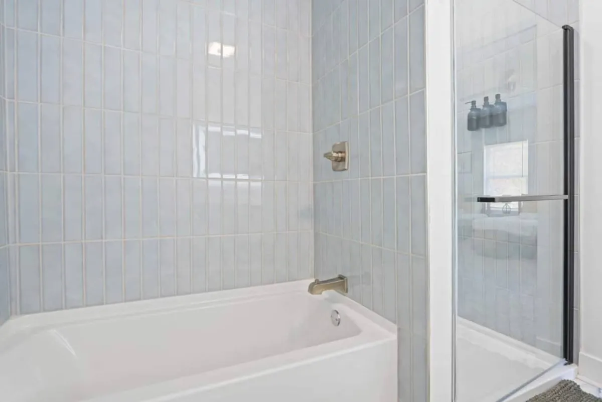 A spa-inspired bathroom with a large soaking tub, glass shower area, and elegant tile walls, evoking a sense of luxury and relaxation—perfect for unwinding after a long day.